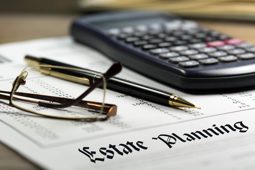 Estate planning documents with glasses, a pen and calculartor